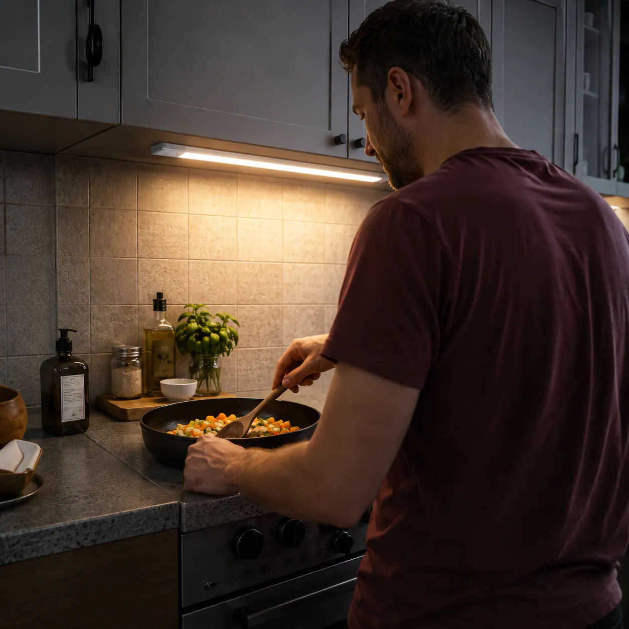 Cocina cálida de un hogar con Lúmina iluminando el rincón bajo los estantes
